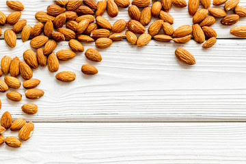 Healthy food. Almond frame on white wooden table top-down copy space