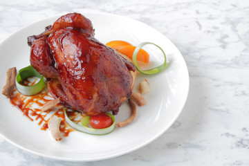  Baked, tasty juicy, quail with spices herbs and soy sauce, beautifully served on a marble table