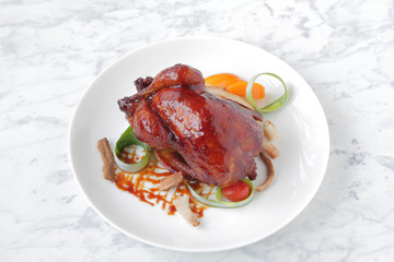 Baked, tasty juicy, quail with spices herbs and soy sauce, beautifully served on a marble table