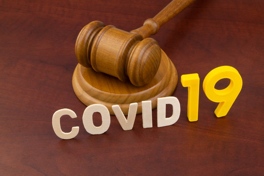 Wooden judge gavel with word covid19. Concept of quarantine and law against covid-19.
