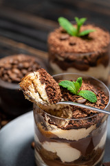 Classic tiramisu dessert in a glass cup on wooden background