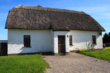 Fototapeta na wymiar Kinvara (Ireland), - July 20, 2016: Traditional Old Irish Cottage with a thatched roof, Co. Galway, Ireland...