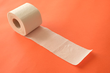 diagonal roll of toilet paper on a pink background