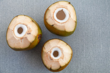 Three green coconuts with holes for straw