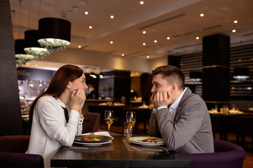 beautiful caucasian couple on a date in rich restaurant. they have dinner together, eat delicious tasty food and drink champagne. happy married couple indoors