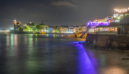 Paisaje urbano de la playa de la ciudad costera de Sitges al atardecer (Cataluña, España).