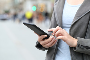 Woman hands using her phone on city street