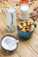 Obraz na płótnie Canvas Muesli balanced protein breakfast. Fruits, berries seeds, nuts, coconut. Coconut beverage and yogurt.