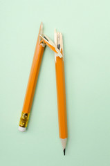 Top view of broken pencil on the light green surface.Concept of stressful situations