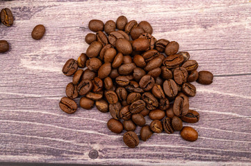 Roasted coffee beans on a wooden background. Close up.