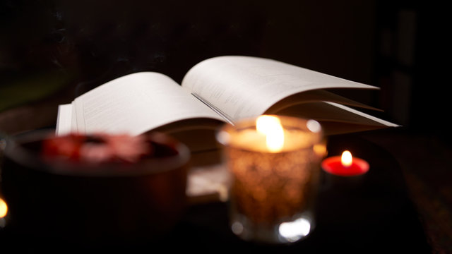 Fortune teller room with open book of predictions on table with candles
