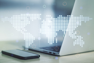 Abstract creative world map on modern laptop background, international trading concept. Multiexposure