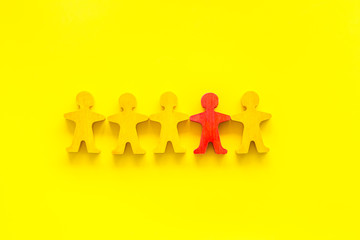 Set of wooden people figures on yellow desk. Human resources, management, hiring concept