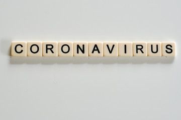 Coronavirus covid19 spelt on scabble tiles on a white background