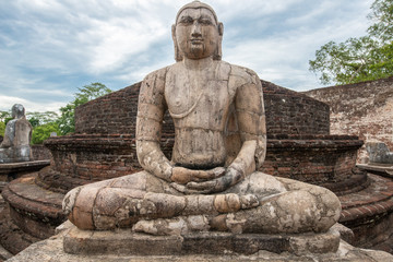 The ancient stone Buddha on the upper platform in the Vatadage, ancient city of Polonnaruwa. Polonnaruwa Vatadage is a circular relic house unique to the architecture of ancient Sri Lanka.
