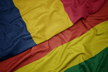 waving colorful flag of bolivia and national flag of chad.