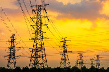 Fototapeta na wymiar Industrial high voltage electricity tower and beautiful nature landscape at summer sunset