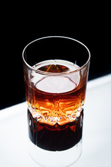 One whiskey glass on a glossy surface