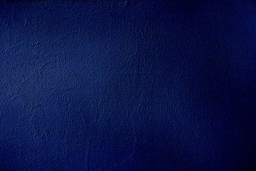 Background of dark blue surface. Color gradient depending on the lighting. Dark blue uneven color. Crumpled sheet of dark blue paper with natural light and shadows. Fragment of a sheet of dark blue 