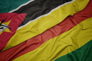waving colorful flag of bolivia and national flag of mozambique.