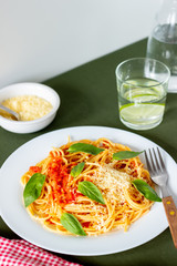 Pasta spaghetti with tomatoes, basil and parmesan cheese. Italian cuisine. Recipe. Vegetarian food. Healthy eating.