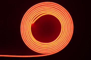 Flexible red LED neon strip on black background