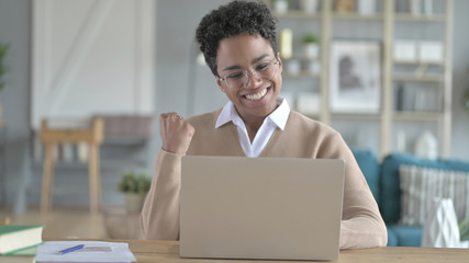 The cheerful Young African Girl working on laptop