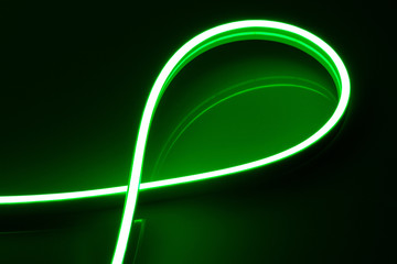 Flexible green LED neon strip on black background