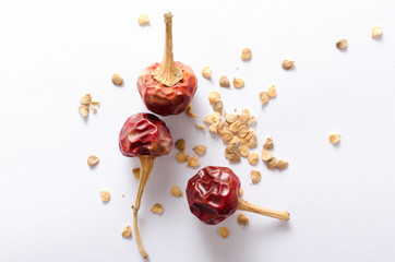 Top view of dry red pepper and red pepper flakes on the white background