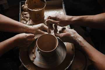 Workshop on modeling of clay on a potter's wheel. The master teaches the student to work with clay