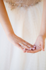 hands of bride wedding ring on background of dress