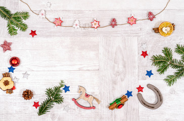 Horse and horseshoe themed Xmas decorations on a plain wood background with space for text