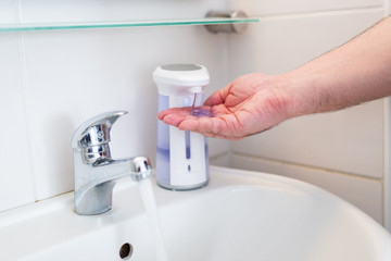 Hygiene concept. Washing hands with soap under the faucet with water, washing hands with soap over...