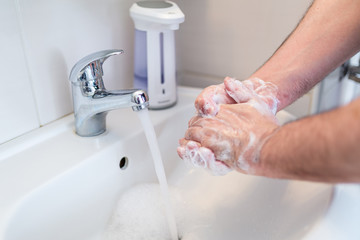 Hygiene concept. Washing hands with soap under the faucet with water, washing hands with soap over...