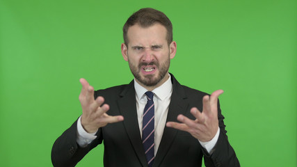 The Frustrated Young Businessman Shouting against Chroma Key