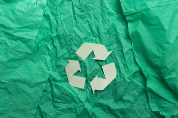 Top view of recycling symbol on the torn green paper.Empty space for design