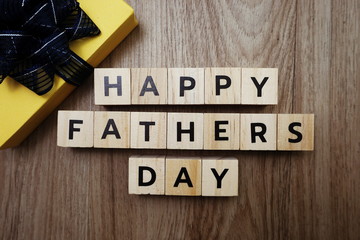 Happy Father's Day alphabet letters with gift box on wooden background