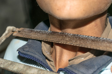 a sharp saw is kept on the neck of a child 