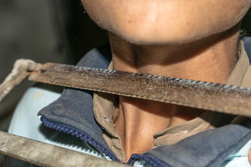 Obraz premium a sharp saw is kept on the neck of a child 