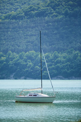 A small yacht floats in the open sea or lake.