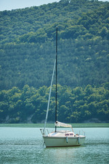 A small yacht floats in the open sea or lake.