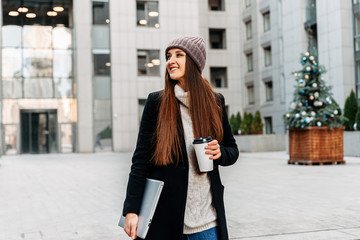 An attractive girl in urban landscape with laptop