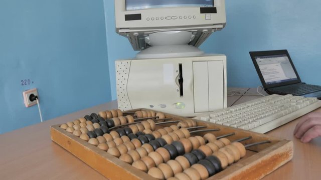 Man Working With Computer, Laptop And Abacus An Ancient Calculator 