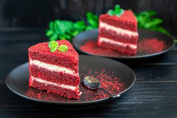Cake Red velvet on two white plates, two servings. On a black background. Birthday, holidays, sweets.