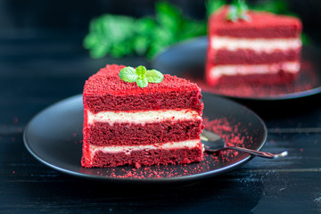 Cake Red velvet on two white plates, two servings. On a black background. Birthday, holidays, sweets.