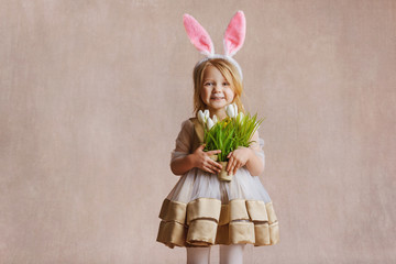 Funny little girl in Easter bunny ears on a free background