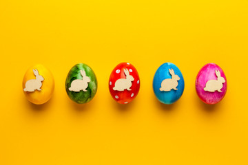Bright easter eggs with bunny (rabbit) on yellow background. Retro colorful spring decoration.