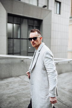Portrait of a handsome man in coat and sunglasses