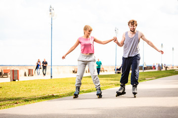 Active young people friends rollerskating outdoor.