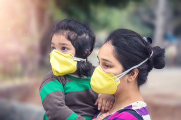 Covid-19 Coronavirus and Air pollution pm2.5 concept.Little Indian baby girl and mother wearing mask for protect and to stop corona virus outbreak 